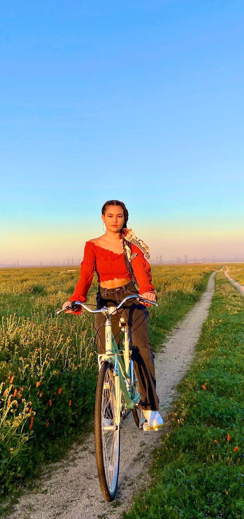 Naomicheyanne riding a pedal bike in an open field. 