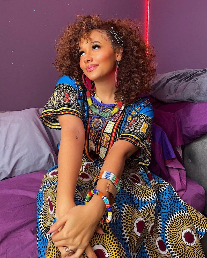 Talia Jackson press photo wearing a colorful African dress 