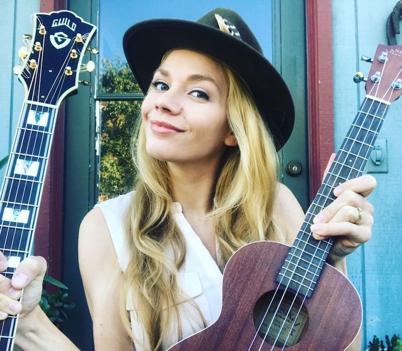 Natalie Gelman press photo outside holding two guitars