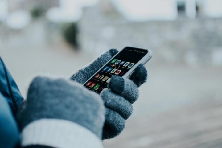 Person wearing gloves holding a cellphone