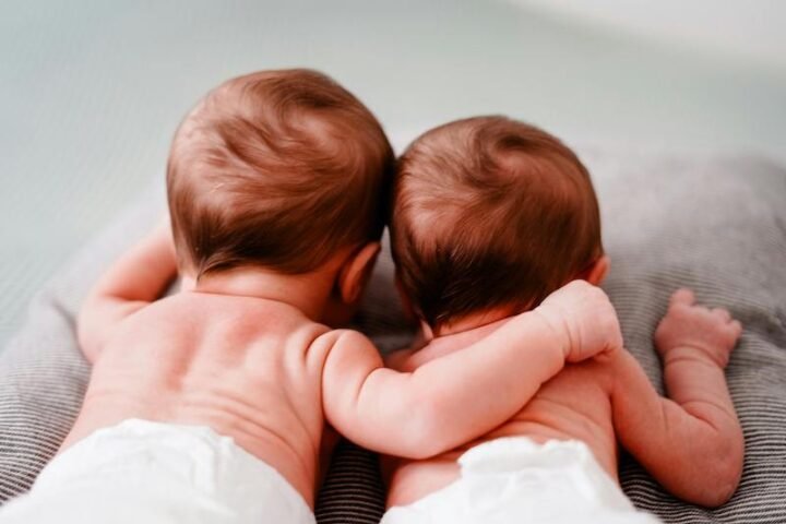 Back view of newborn twins lying close to each other