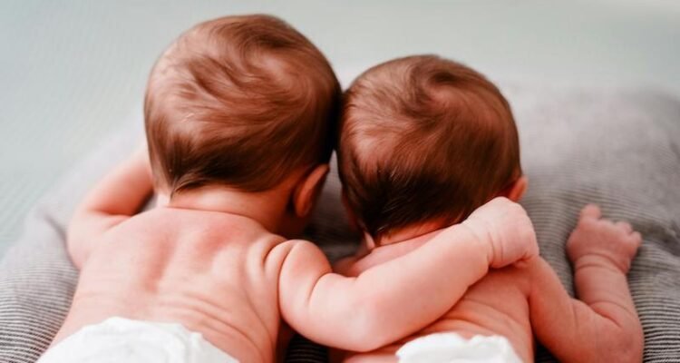 Back view of newborn twins lying close to each other